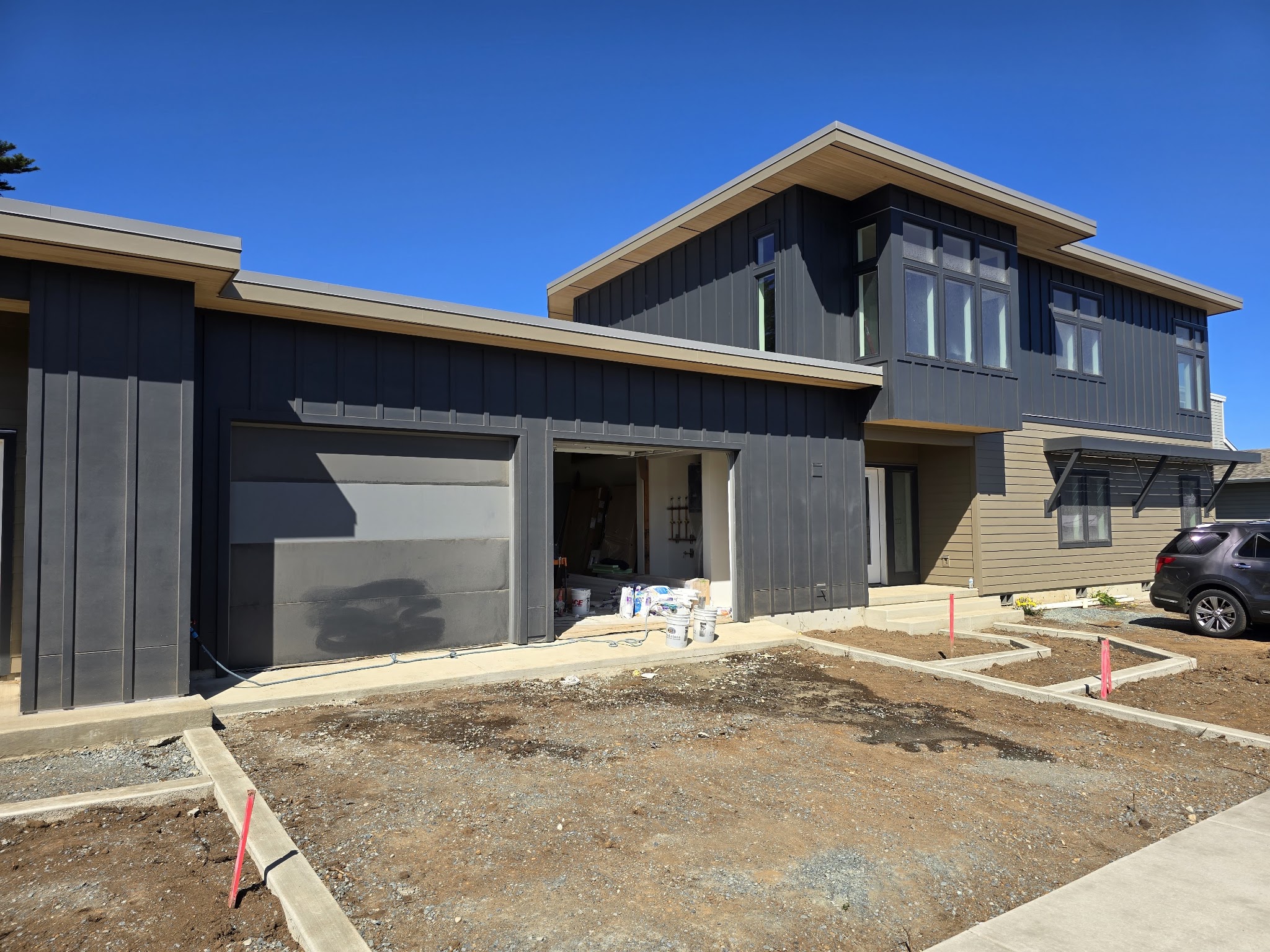A finished two-story modern home with dark board-and-batten siding