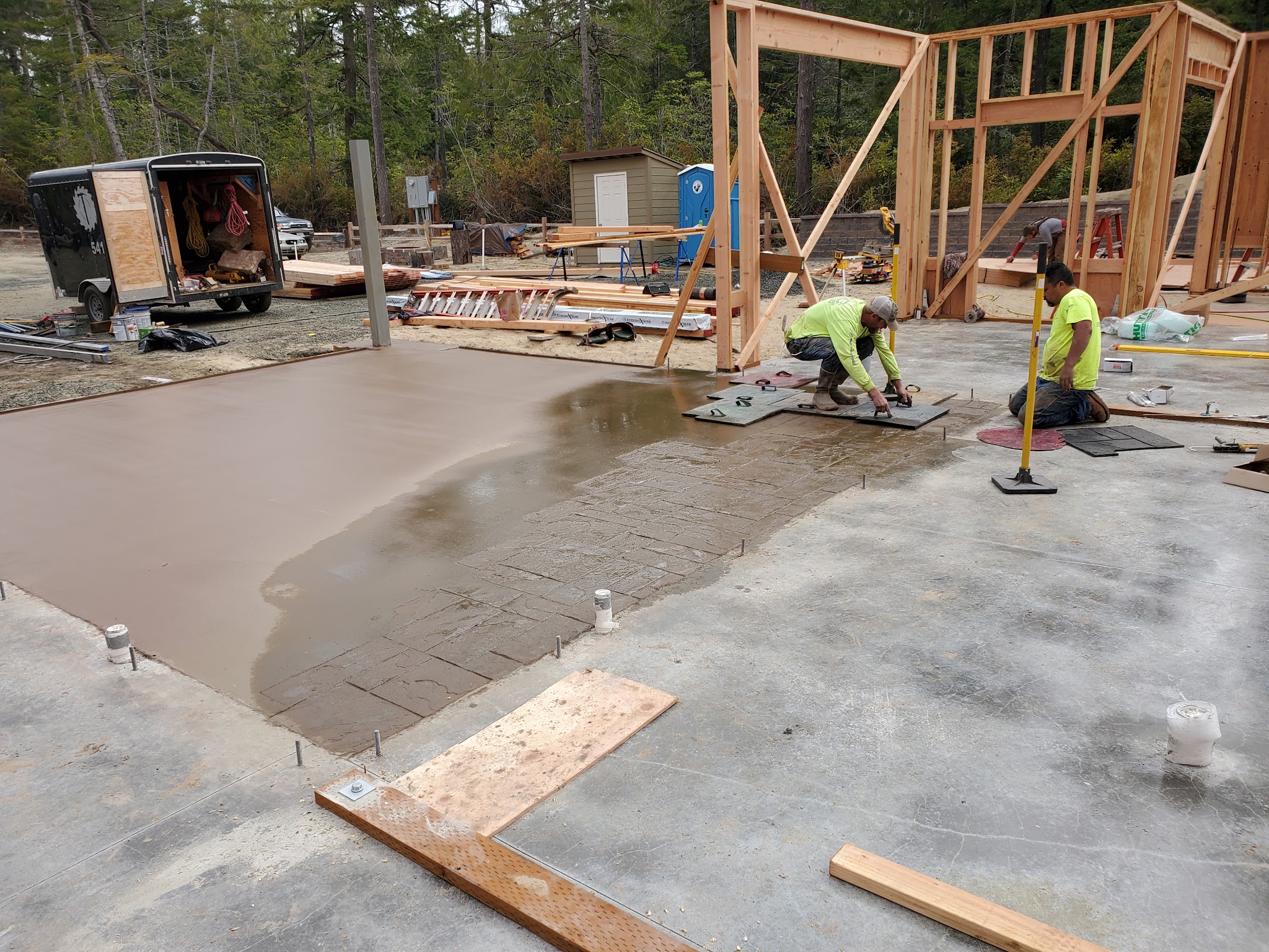 Crew finishing a stamped concrete patio pour