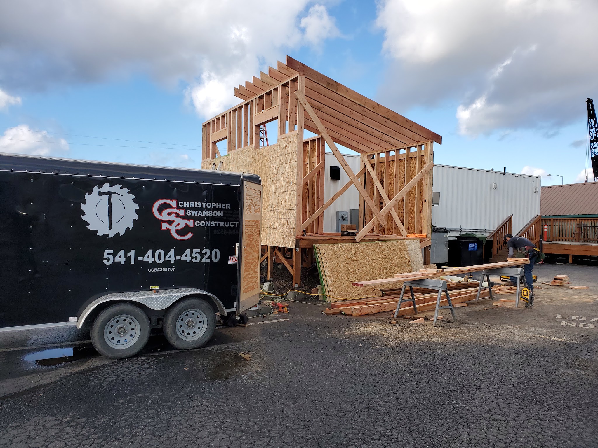 The Christopher Swanson Construction work trailer parked at a framing job site