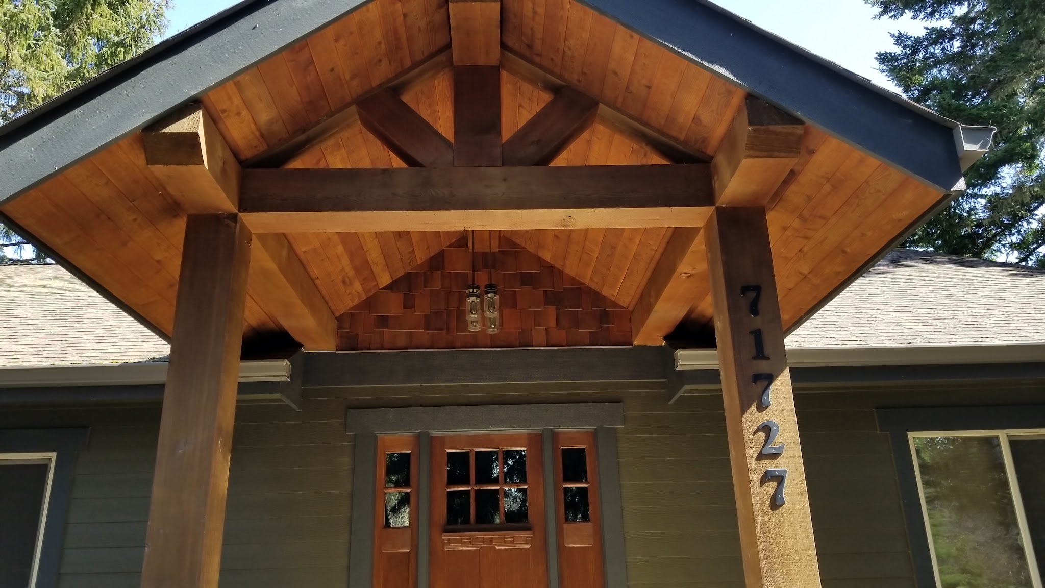 A finished timber-frame covered entry with house numbers